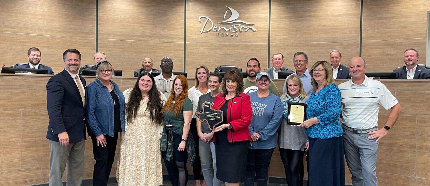 Standing left to right: Denison leaders recognized the local participants in the award-winning Ecommerce Accelerator Incentive program Monday night at the City Council meeting. Present to represent the program were: William Myers, DDA; Elsie Russell, 2 Chicks Home and Market; Jenna Zapata, Zig Zag Galleries; Neal Spencer, Spiffy Spa; Natalie Popplewell, 410 Collective + Coffee; Cathy Cobb, Totally Addicted; Nitia Musico, Monsters on Main; Denison Mayor Janet Gott; Derrick Roberts, Pop Around the Corner; Kimberlea Donohoe-Miller, The Hangin T; Wendy Acosta, The Desk and Easel; Tony Kaai, DDA; Donna Dow, Denison Main Street; and Michael McKinley, Avert 360. Seated left to right, Council members: Brian Hander, Dr. Michael Courtright, Robert Thorne, J.C. Doty, Robert Crawley and Kristofer Spiegel.